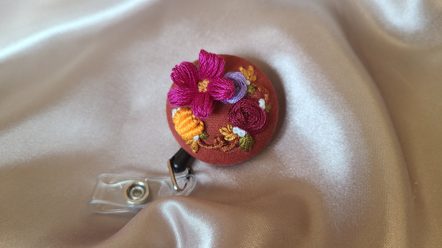 Magenta Petunia with Orange Mini Pumpkin Wreath on Pumpkin Spice Orange Hand Embroidered Retractable Badge Reel